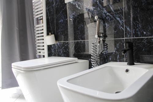 a bathroom with a white toilet and a sink at La rosa dei pepoli in Castiglione dei Pepoli
