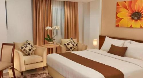 a hotel room with a large bed and a chair at Bogor Valley Hotel in Bogor