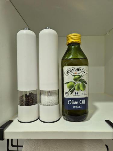 a bottle of olive oil and two candles on a shelf at Greenhills Retreat in Kuranda