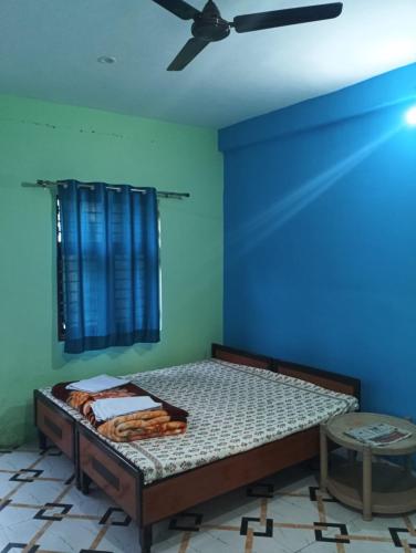 a bedroom with a bed and a ceiling fan at saraswati home stay in Pālampur