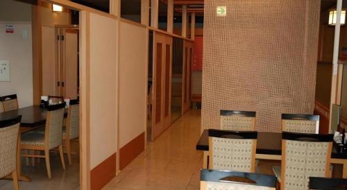 a room with tables and chairs in a building at Albert Hotel in Akita