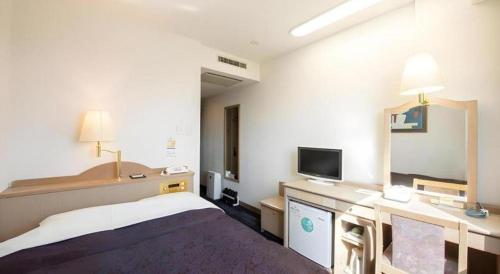 a hotel room with a bed and a tv at Albert Hotel in Akita