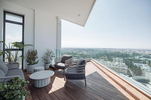 a living room with chairs and a table on a balcony at SkyHigh Park View Living in Nicosia