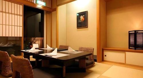 a dining room with a table and chairs at Luxury Wa Hotel Kaze No Kaori in Ito