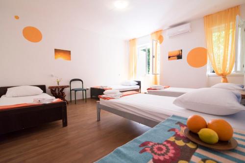 a bedroom with two beds and a table with fruit on it at D&D Holiday Home in Supetar