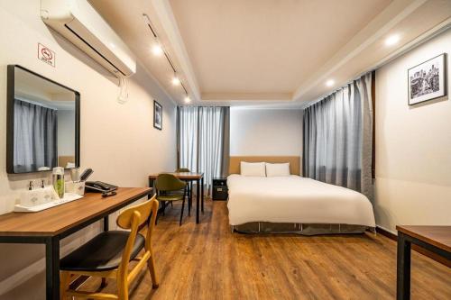 a hotel room with a bed and a desk at Check Inn Hotel in Jeju