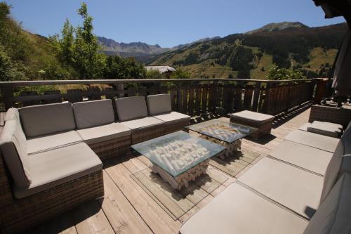 un patio avec un canapé et une table sur une terrasse dans l'établissement Chalet le Chantelevent for 24 Guests - Slope Views, Pool & Jacuzzi, à Vars
