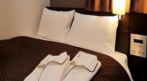 a bed with two napkins on top of it at Daini Fuji Hotel in Nagoya