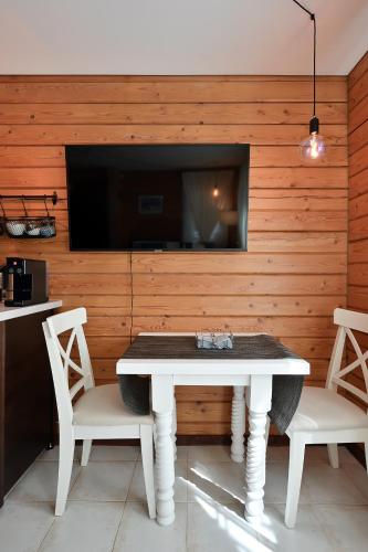 a dining room with a table and two chairs and a tv at Romantic cozy house Kirzacinas pirts with sauna close to seaside in Skulte