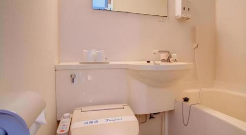 a white bathroom with a toilet and a sink at Okinawa Sunplaza Hotel in Naha