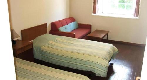 a room with a bed and a chair in it at Petit Hotel Key West Club in Naha