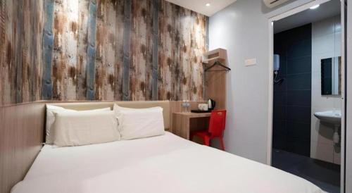 a bedroom with a white bed and a bathroom at Cappuccino Hotel @ Mount Austin in Johor Bahru