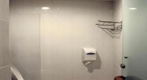 a white bathroom with a toilet and a shower at Hotel Kristal in Seri Iskandar