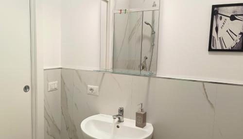 a white bathroom with a sink and a mirror at La Casa di Pepe - Cascate delle Marmore in Terni