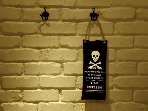 a black bag hanging on a brick wall at The Shop Hotel in Kuala Kangsar