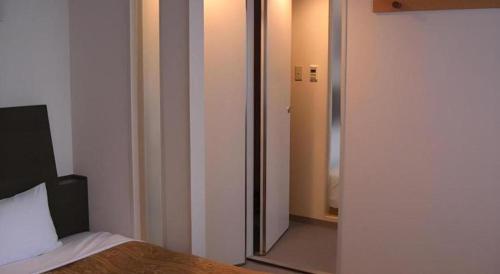 a bedroom with a door leading to a mirror at Hirata Maple Hotel in Izumo