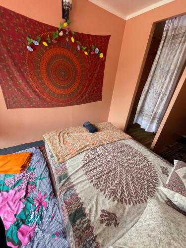 a bedroom with a bed and a tapestry on the wall at Shanti Shanti Ganga View in Rishīkesh