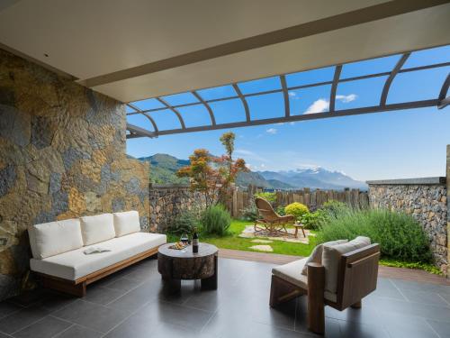 a living room with a couch and a chair at Lijiang Jijian Xiangwang SOOOAN Luxury Resort Hotel in Lijiang
