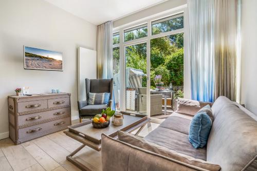a living room with a couch and a dresser at Das 54 Grad Nord - Apartments & More in Hörnum