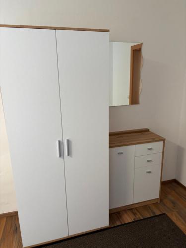 une cuisine avec une armoire blanche et un comptoir dans l'établissement Ferienwohnung im Stadtteil Waiern in Feldkirchen in Kärnten, à Feldkirchen in Kärnten