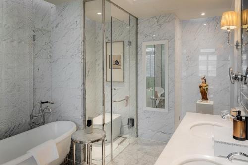 a bathroom with a tub and a sink and a shower at Sofitel Legend People's Grand Hotel Xi'an in Xi'an