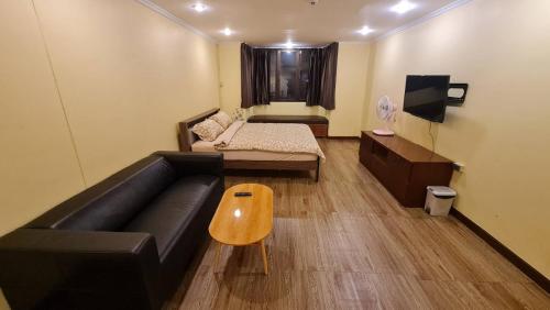 a living room with a couch and a bed at Comfort 1BR 2 King Beds, Best Value Stay, near Bts Nana in Bangkok