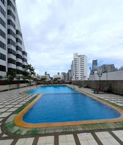 a large swimming pool in the middle of a city at Comfort 1BR 2 King Beds, Best Value Stay, near Bts Nana in Bangkok