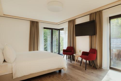 a bedroom with a bed and a table and chairs at Hotel Chalet Corso in San Vigilio Di Marebbe