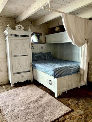 a bedroom with a white bed with a canopy at La Grange avec Jacuzzi in Loguivy-Plougras