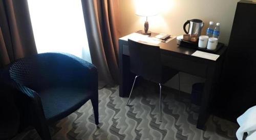 a room with a desk and a chair and a lamp at Eminent Hotel in Kota Kinabalu