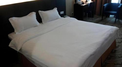 a large white bed in a hotel room at Eminent Hotel in Kota Kinabalu