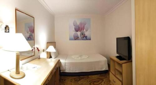 a hotel room with a bed and a television at The Orchid Hotel in Sibu