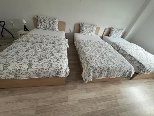 a bedroom with two beds and a wooden floor at Gyeongju BonghwangMansion in Gyeongju