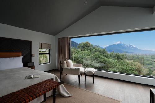 a bedroom with a large window with a view at Lijiang Jijian Xiangwang SOOOAN Luxury Resort Hotel in Lijiang