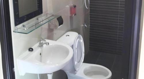 a bathroom with a white sink and a toilet at Admiral Hotel in Sitiawan