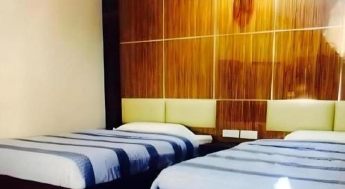 two beds in a hotel room with at Admiral Hotel in Sitiawan