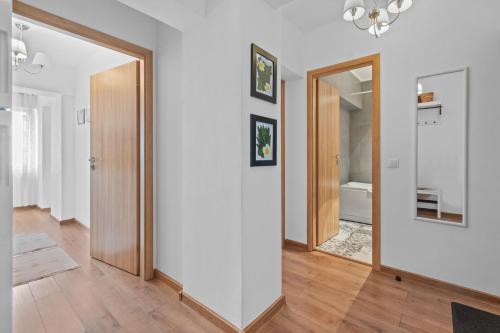 a hallway with a door and a mirror at Spitalul Bagdasar & Obregia - Sudului 507 by MRG Apartments in Bucharest