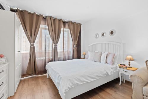 a white bedroom with a bed and a window at Spitalul Bagdasar & Obregia - Sudului 507 by MRG Apartments in Bucharest
