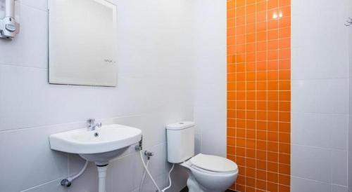 a bathroom with a sink and a toilet and a mirror at Big Orange Hotel Jitra in Alor Setar