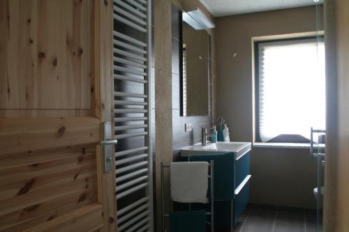 een badkamer met een wastafel en een spiegel bij Ferienhaus Geipel in Wohlbach