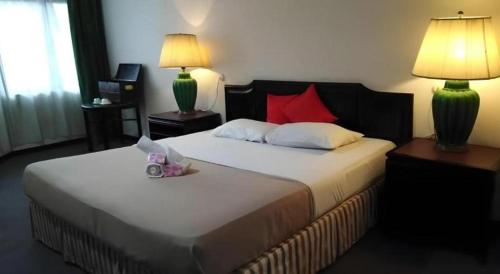 a bedroom with a large white bed with two lamps at Hotel Centrepoint (Self Check In After 5PM) in Kuala Lipis