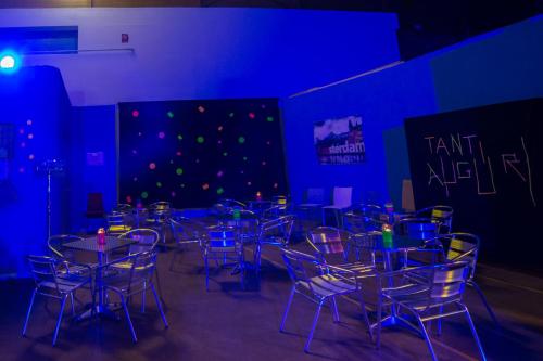 a room with tables and chairs in a blue room at Ostello Salento in Alezio