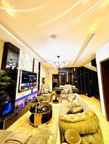 a large living room with couches and a flat screen tv at 4 Bedroom Self compound Duplex with pool and bq in Ikate Lekki in Lekki