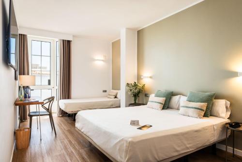 a hotel room with a large bed and a table at Hotel Patricia Menorca in Ciutadella