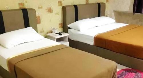 two beds sitting next to each other in a room at RST Hotel in Johor Bahru