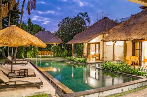 an image of a resort pool with chairs and umbrellas at Villa Blubambu in Seminyak
