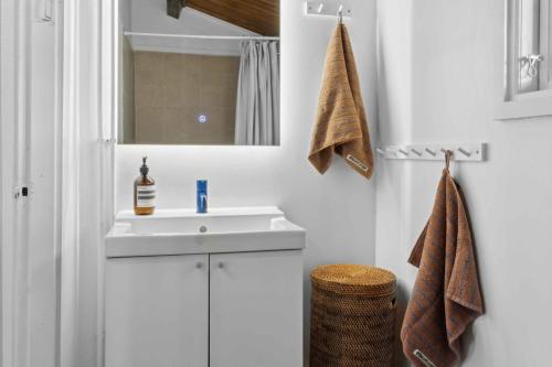 ein Badezimmer mit einem weißen Waschbecken und einem Spiegel in der Unterkunft Cozy Holiday Home Near Rødby in Rødby