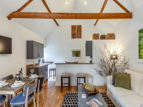 a living room with a couch and a table at Midsummer Cottage Retreat in Pilton