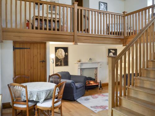 a living room with a table and a blue couch at Buddileigh Farm in Betley