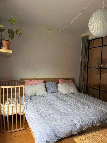 a large bed in a bedroom with a crib at Bright, child-friendly, balcony, 50 meters from the subway in Copenhagen